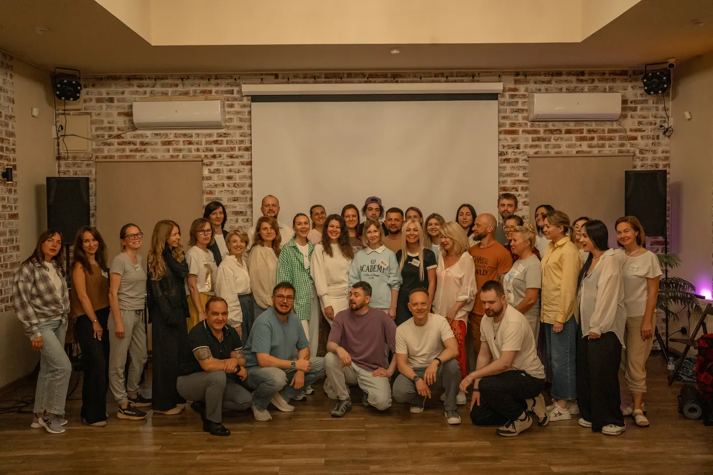 Большая групповая фотография участников на траве, атмосфера ретрита